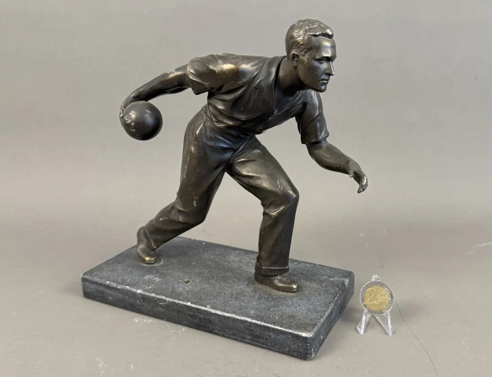 Skulptur eines Mannes beim Kegeln, um 1920/35 Metall, goldfarben patiniert; auf schwarzen Marmorsockel montiert; Alters- und Gebrauchsspuren, H23 cm, L 21 cm.